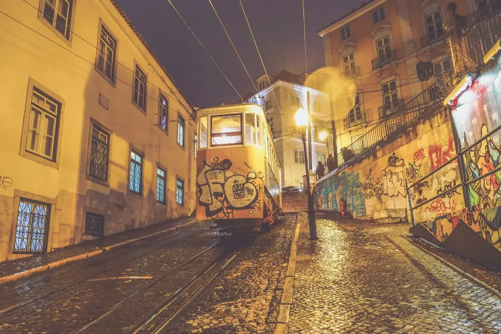 Lisbon funicular at night on a steep street by Bairro Alto